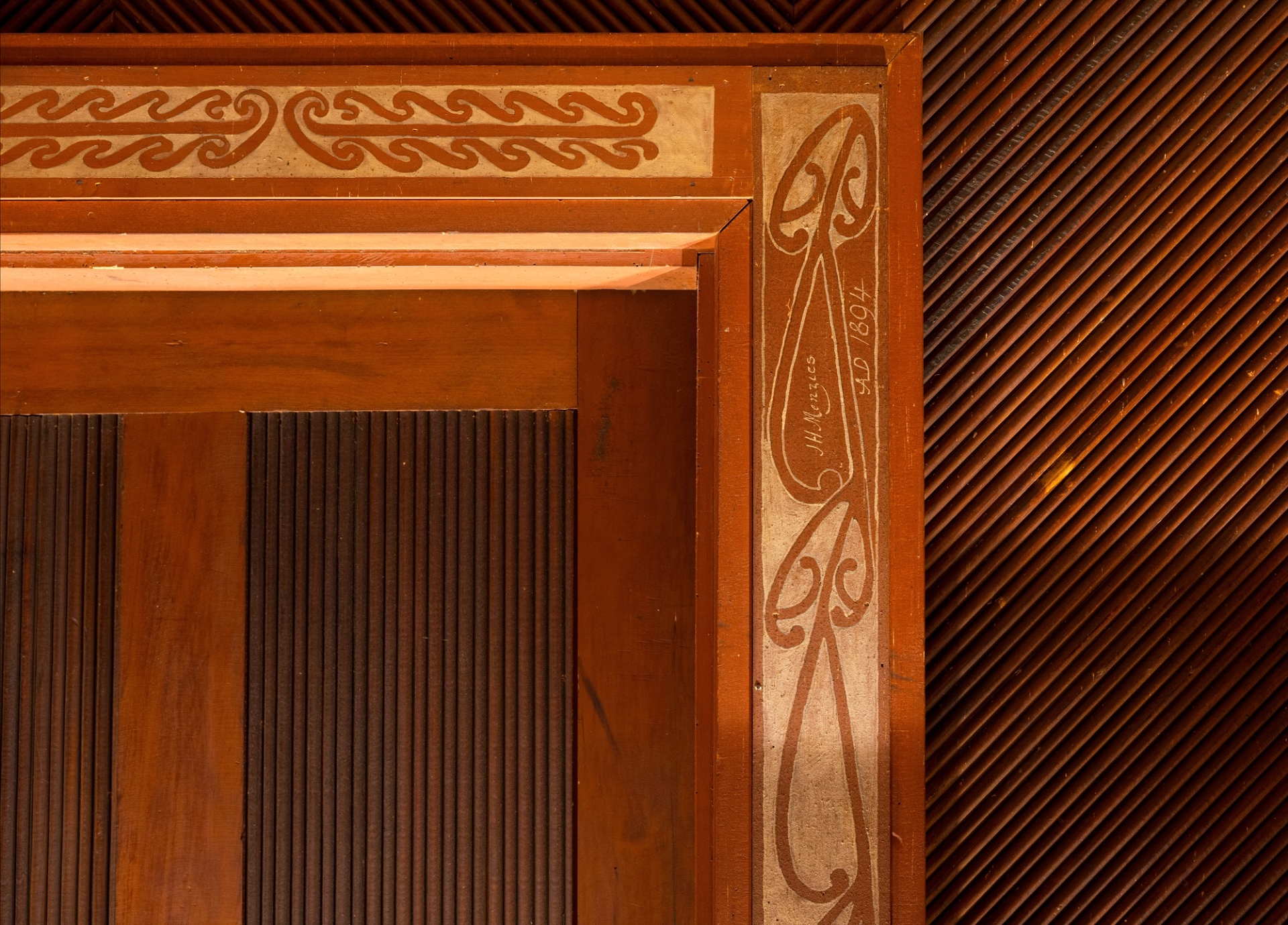 A carved and painted doorway from the original homestead, the pilaster inscribed by its maker: J. H. Menzies, AD 1894.